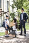 Chinese parents with schoolboy on street in morning — Stock Photo
