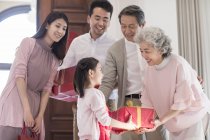 Nieta dando regalos a los abuelos durante el año nuevo chino - foto de stock