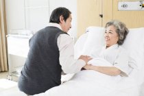 Chinese senior man visiting wife in hospital — Stock Photo