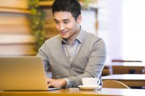 Homem chinês usando laptop no café — Fotografia de Stock