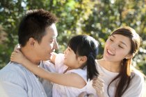 Glückliche chinesische Eltern tragen Tochter in Park — Stockfoto