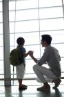 Китайские отец и сын смотрят на вид в аэропорту — стоковое фото