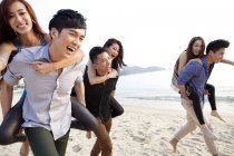 Chinese people playing piggyback on beach in Repulse Bay, Hong Kong — Stock Photo