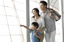 Familia china señalando en vista en el aeropuerto - foto de stock