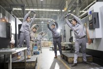 Chinese engineers stretching at industrial factory — Stock Photo