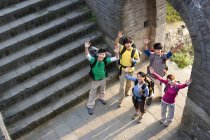 Group of Chinese backpackers waving on Great Wall — Stock Photo