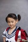 Chinese girl in school uniform with backpack — Stock Photo