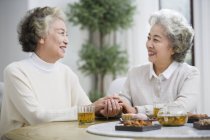 Mujeres chinas mayores hablando y bebiendo té - foto de stock