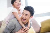 Chinese father carrying daughter on back — Stock Photo