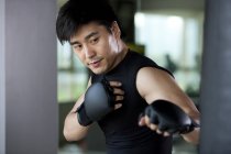 Portrait of Chinese man boxing in gym — Stock Photo