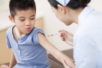 Chinese nurse giving boy injection — Stock Photo