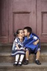 Chinesisch schuljunge küssen schulmädchen auf veranda — Stockfoto