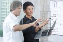 Designers drawing sketch on glass wall — Stock Photo