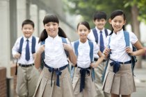Chinese schoolchildren in school uniform posing in street — Stock Photo