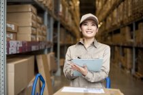 Female Chinese warehouse worker doing inventory — Stock Photo
