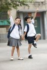 Crianças chinesas com mochilas posando na rua — Fotografia de Stock