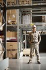 Male Chinese warehouse worker standing with hands on hips — Stock Photo
