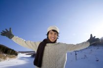 Homem chinês em suéter com os braços estendidos — Fotografia de Stock