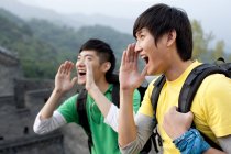 Chinesische männliche Freunde schreien auf großer Mauer — Stockfoto