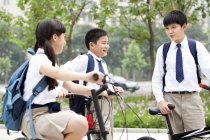 Chinese schoolchildren with bicycles outdoors — Stock Photo