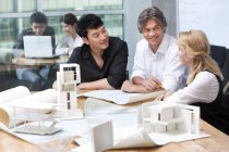 Team of architects discussing blueprints — Stock Photo