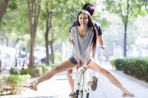 Chinese woman riding bicycle together with man — Stock Photo