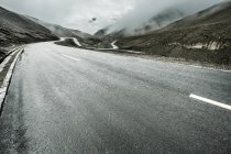 Camino en las montañas con curva de horquilla en el Tíbet, China - foto de stock