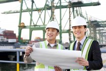 Chinese shipping industry professionals looking over blueprints — Stock Photo