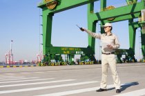 Männlicher chinesischer Schifffahrtsarbeiter zeigt mit Walkie-Talkie — Stockfoto