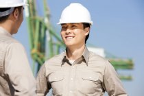 Male Chinese shipping industry workers talking — Stock Photo