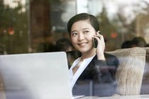 Chinese businesswoman talking on phone in cafe — Stock Photo