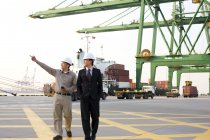 Trabalhador da indústria naval chinesa mostrando porto para homem de negócios — Fotografia de Stock