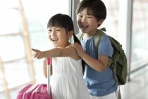 Китайський хлопчик і дівчинка, вказуючи на подання в аеропорту — стокове фото