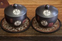 Chinese tea caddies with ornaments on mats — Stock Photo