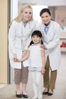 Китайские врачи и девочка в детской больнице — стоковое фото