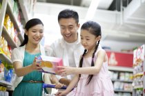 Família chinesa escolhendo cookies no supermercado — Fotografia de Stock