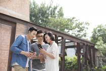 Chinesische Freunde nutzen Smartphone auf der Straße — Stockfoto