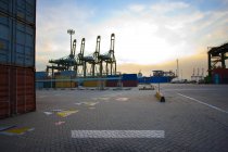 View of cranes, containers and cargo ships at dusk — Stock Photo