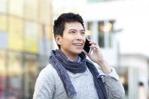 Fashionable Chinese man talking on phone on street — Stock Photo