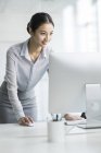 Китайський бізнес-леді за допомогою комп'ютера в офісі — стокове фото