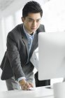 Uomo d'affari cinese che utilizza il computer in ufficio — Foto stock