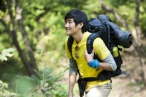 Chinese backpacker on the move in forest — Stock Photo