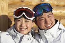 Casal chinês em óculos de esqui sorrindo na câmera — Fotografia de Stock