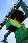 Низький кут огляду кранів та вантажних контейнерів у морському порту — стокове фото