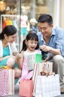 Pais chineses surpreendente filha com presente no shopping — Fotografia de Stock