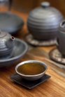 Крупный план чашки с травяным чаем и чайниками — стоковое фото
