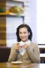 Chinesin trinkt Kaffee im Café — Stockfoto