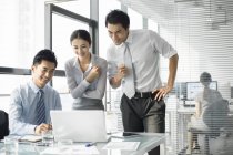 Китайская команда бизнесменов использует ноутбук в офисе — стоковое фото