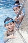 Niños chinos en gafas de natación junto a la piscina - foto de stock