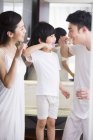 Genitori cinesi con figlio lavarsi i denti — Foto stock
